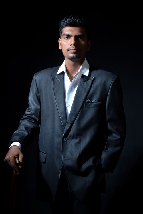 Free Sophisticated portrait of a man in a suit against a black background, exuding confidence and style. Stock Photo