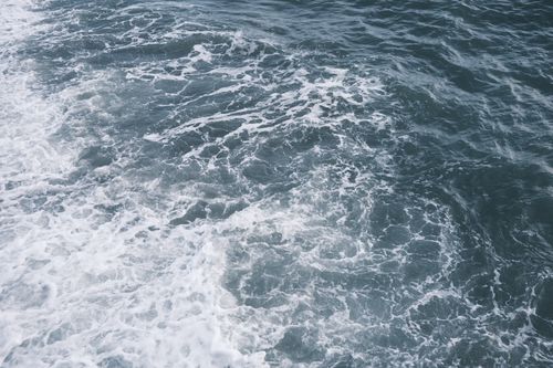 Free A captivating aerial view of ocean waves forming intricate foam patterns. Stock Photo