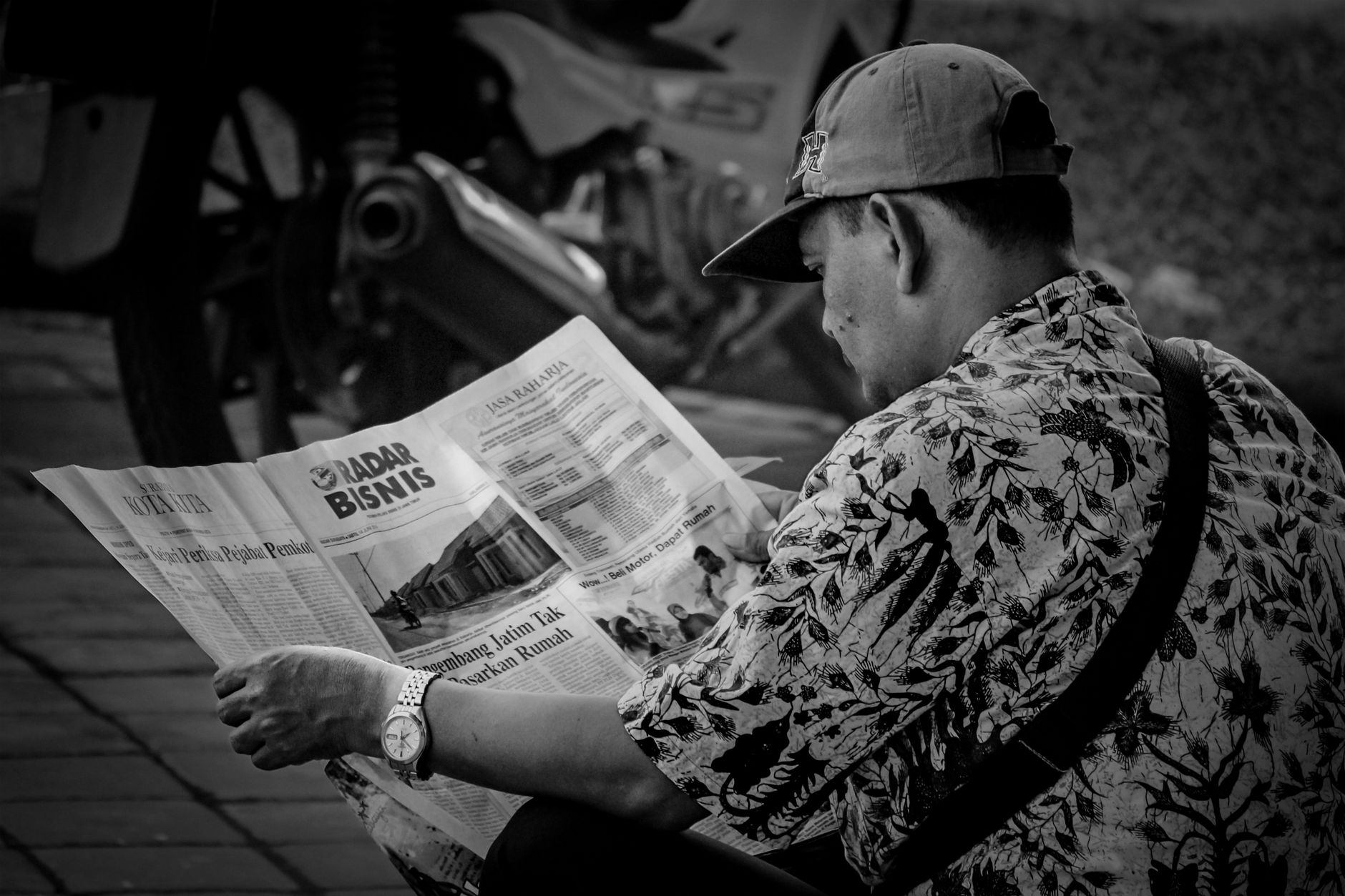 Seorang pembaca memeriksa situs taruhan daring di laptop dengan catatan regulasi dan kalkulator risiko