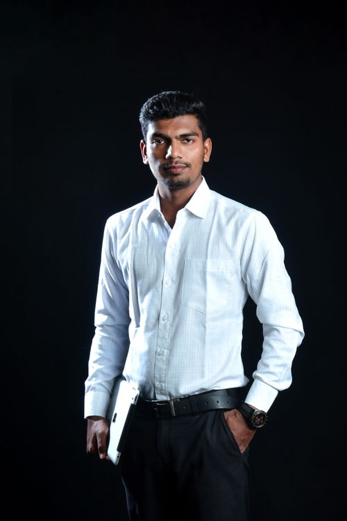 Free Elegant portrait of a man in a white shirt, standing confidently against a black background. Stock Photo
