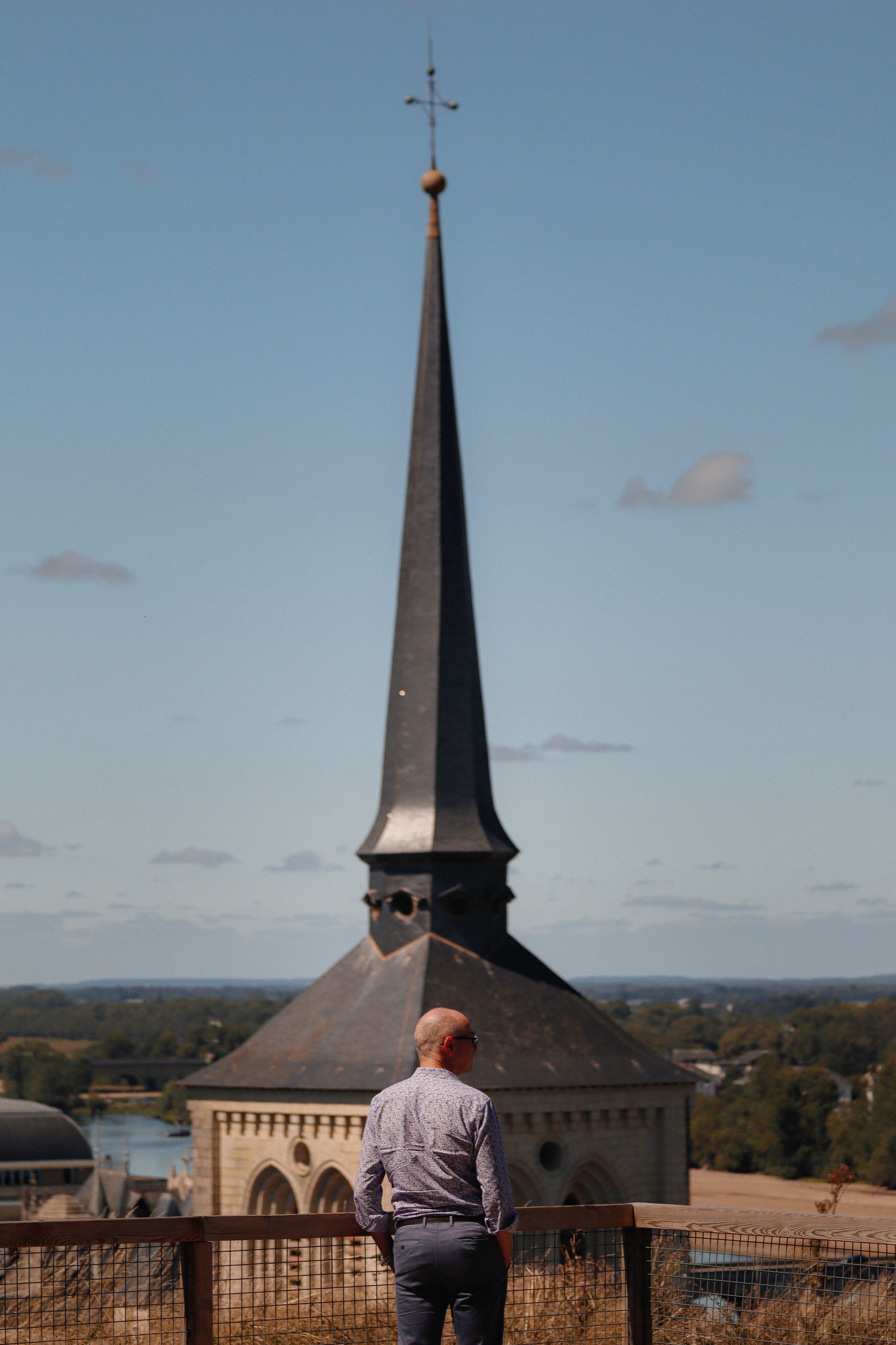Man Standing with Church Tower behind · Free Stock Photo