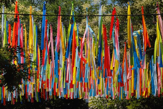 Vivid colorful ribbons hanging outside, creating lively decoration against greenery.