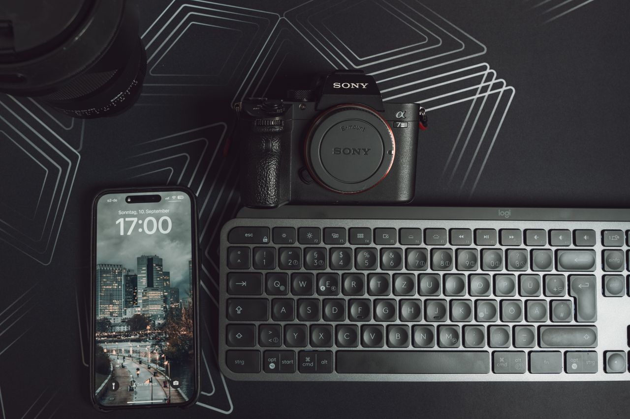 elegant workspace setup featuring camera smartphone and keyboard on a