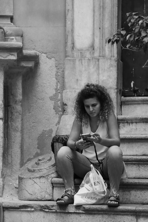 Free Black and white photo of a woman sitting on steps in Palermo, Sicily, Italy. Stock Photo