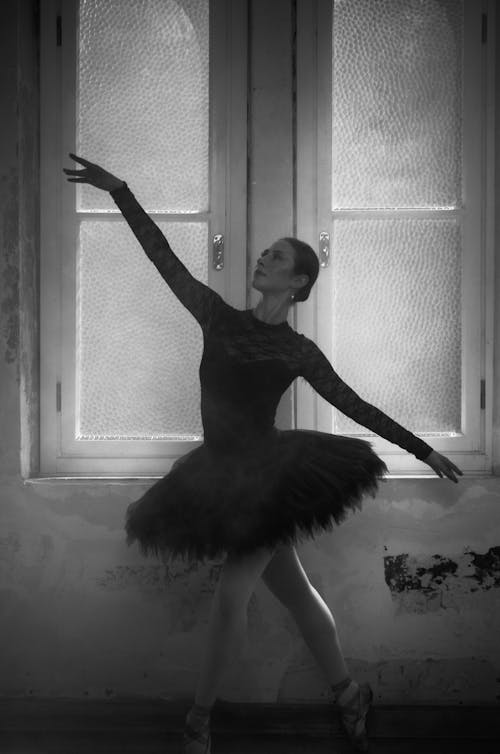 Ballerina Dancing on the Background of a Large Window