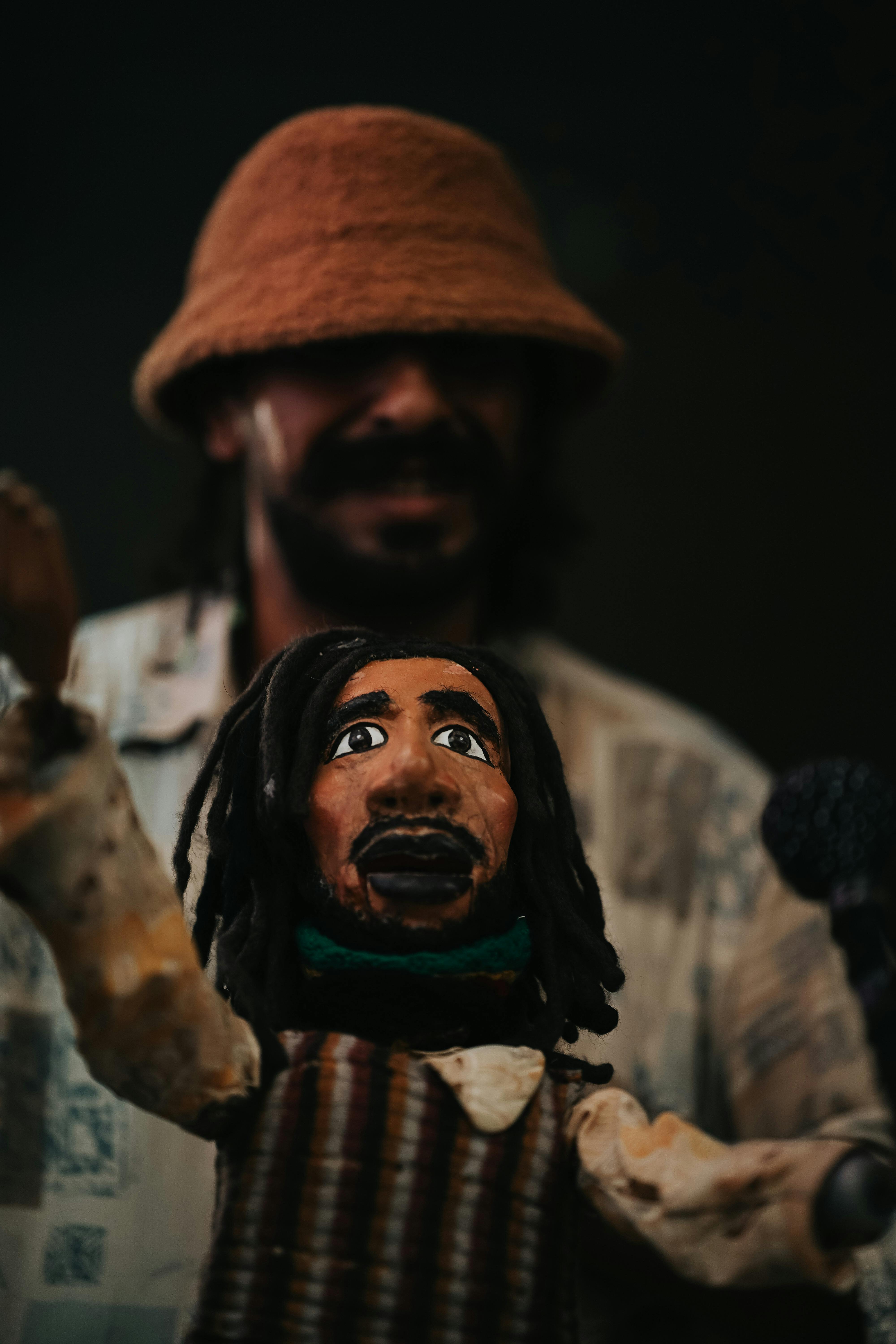 Close-up of a handmade figurine with a hat, capturing traditional craftsmanship in a shadowy backdrop.