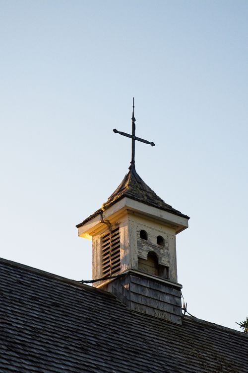Free A rustic church steeple topped with a cross, symbolizing faith and spirituality. Stock Photo