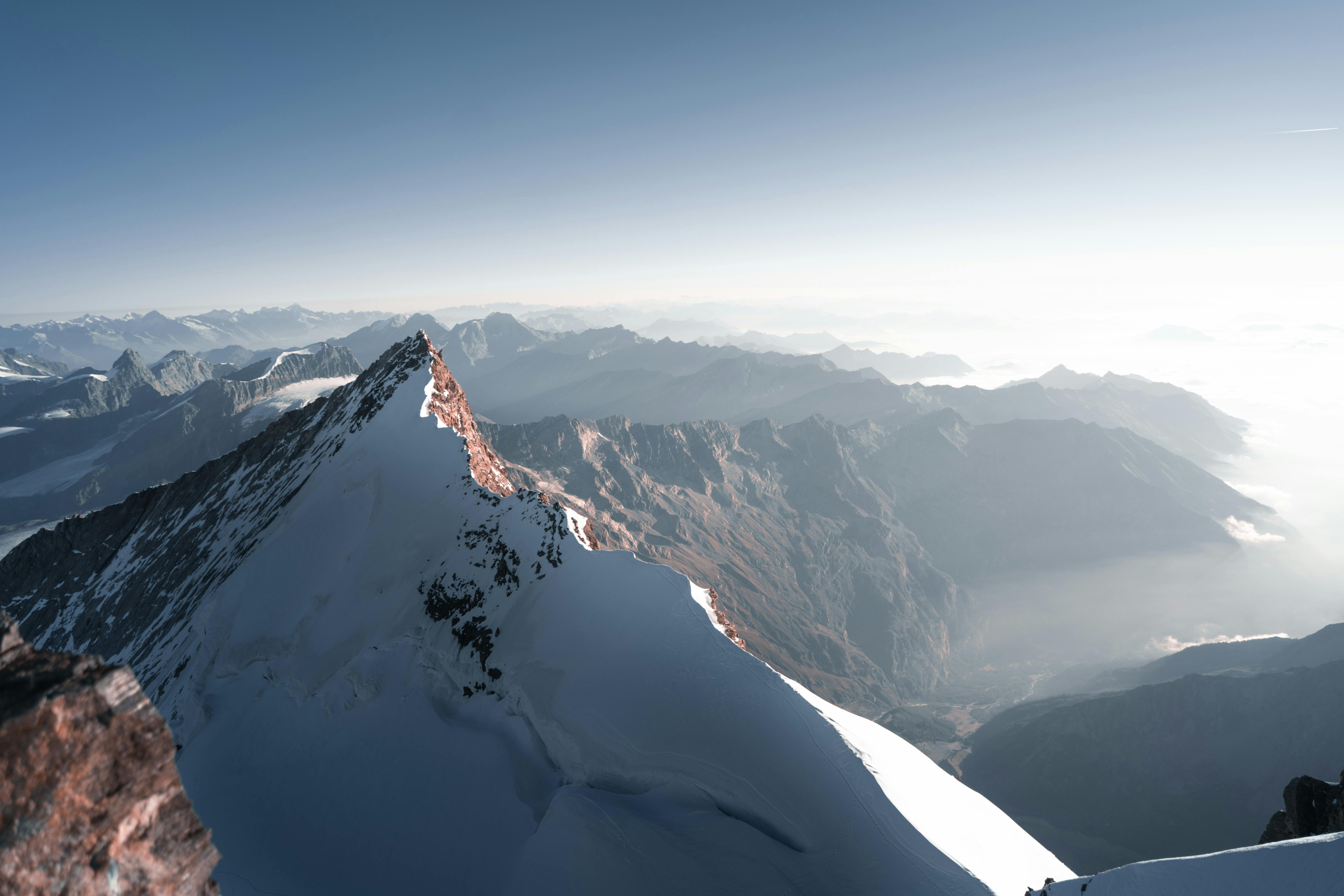 Prescription Goggle Inserts - Breathtaking view of a snow-covered mountain peak with a vast landscape at sunrise, highlighting natural beauty.