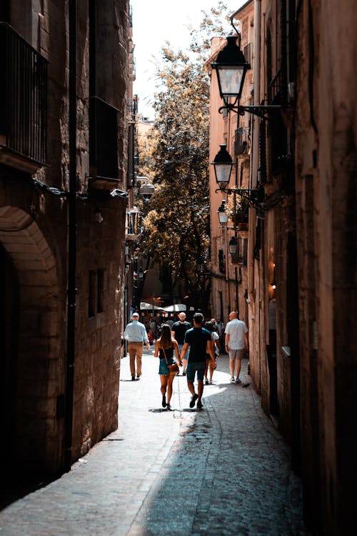 People walking down a narrow street in a city