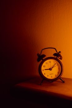A classic analog alarm clock in warm, moody lighting, symbolizing timelessness.