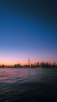 Stunning view of Toronto skyline at dusk with CN Tower reflecting in the water.