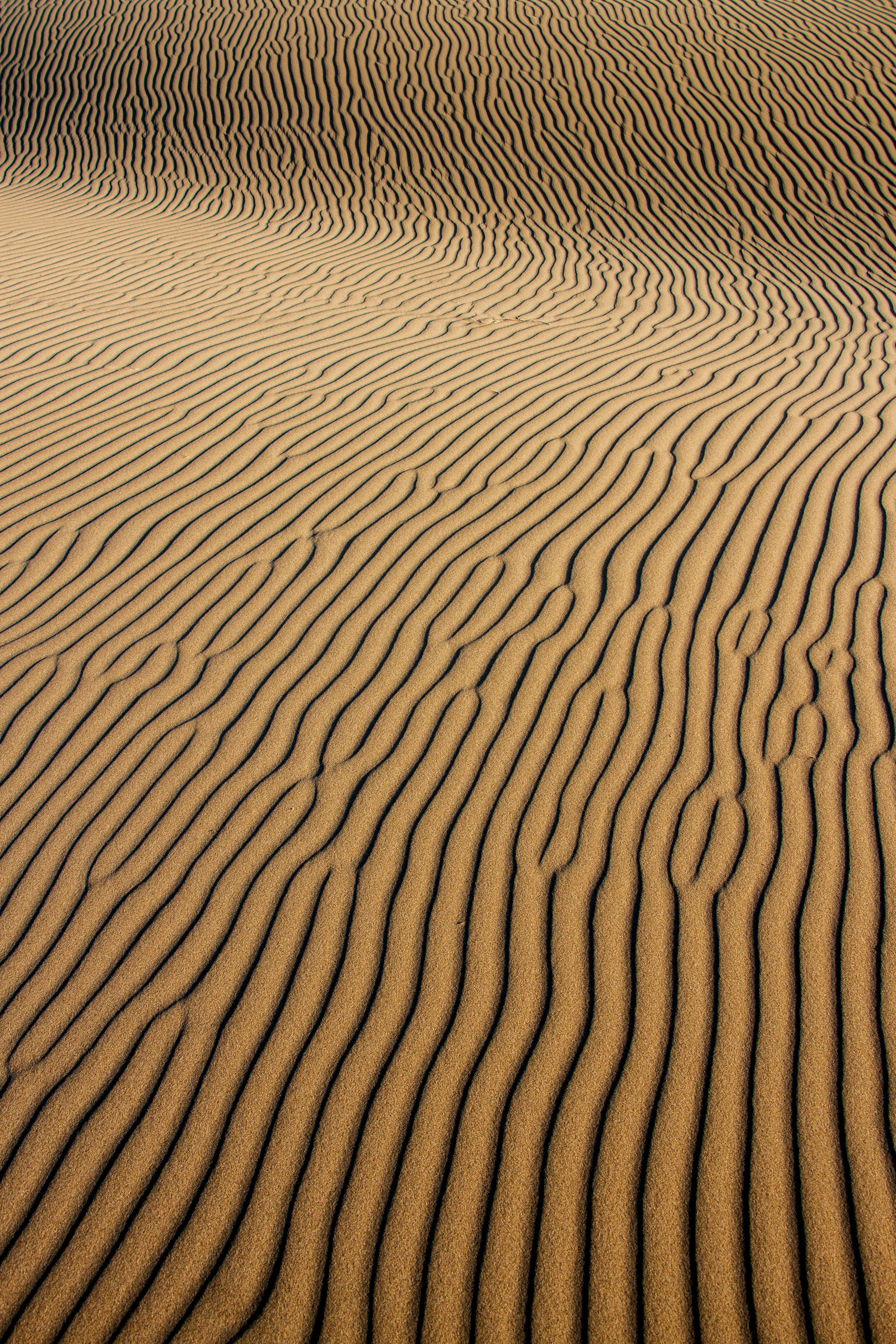 Captivating patterns in Iran's desert sand dunes, showcasing nature's artistry.