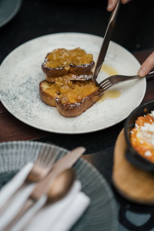 Free Close-up of French toast topped with fruit jam served on a plate, silverware included. Stock Photo