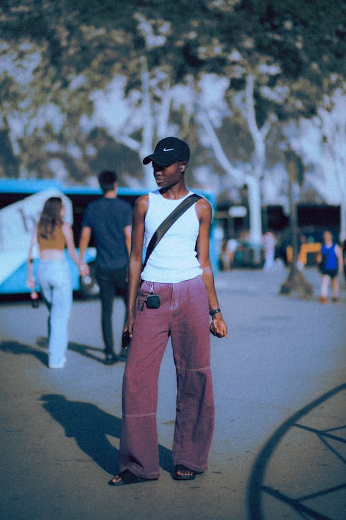 Young Woman in Jeans and Baseball Hat Standing on Street