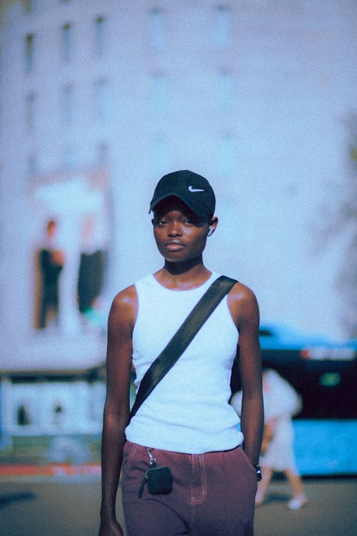 Woman in White Tank Top and Black Baseball Cap