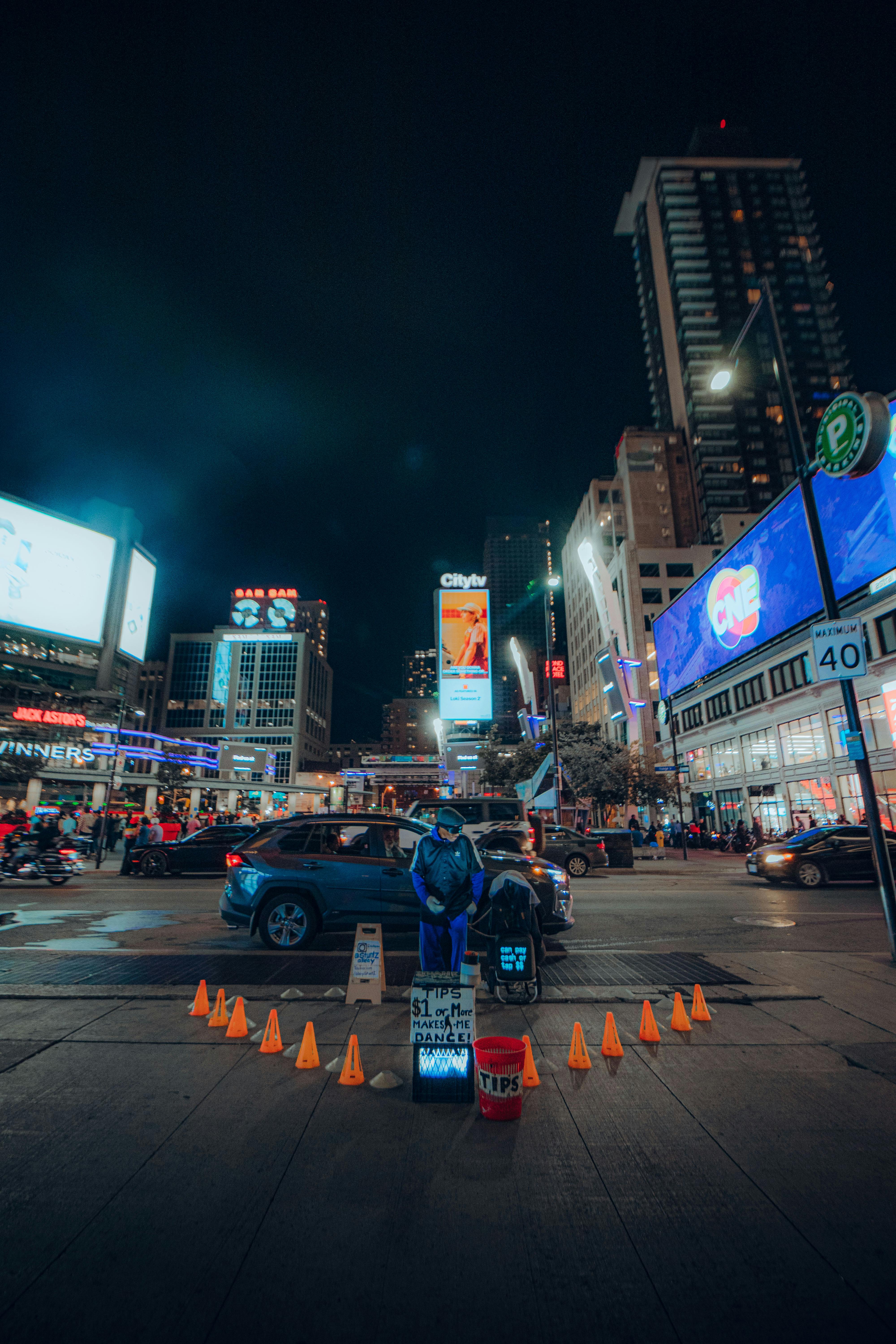 Bustling city intersection at night with illuminated buildings and busy streets.