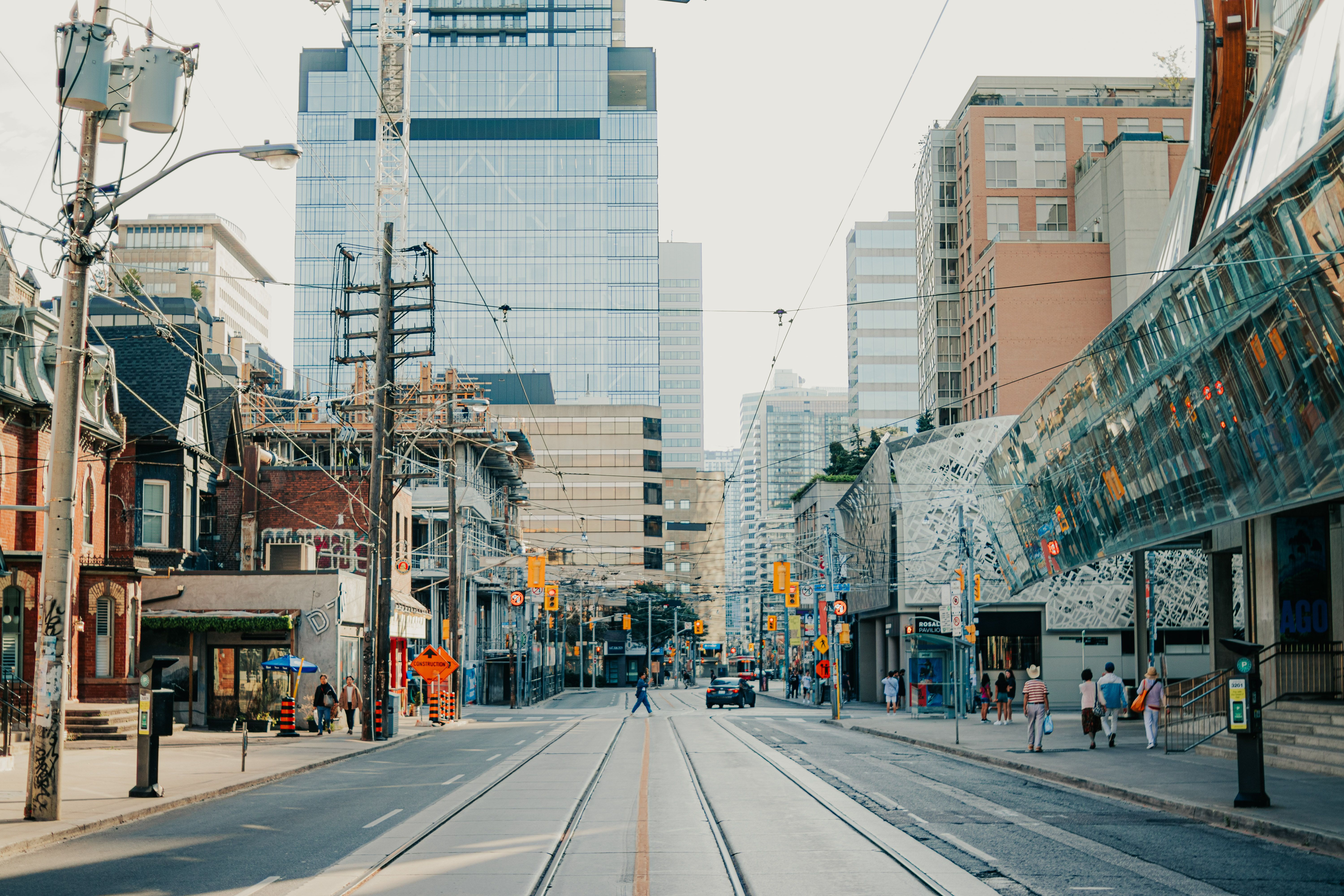 Dynamic Toronto city street scene with pedestrians and modern skyscrapers under clear sky.
