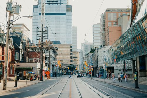 Free Dynamic Toronto city street scene with pedestrians and modern skyscrapers under clear sky. Stock Photo