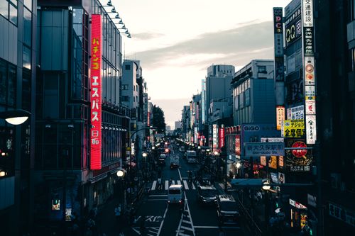 Free Street view in Tokyo's downtown district filled with neon signs and traffic during twilight. Stock Photo