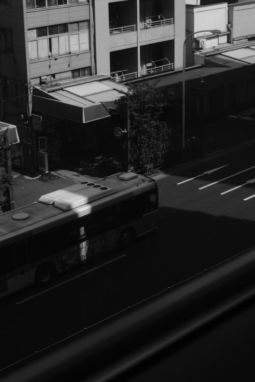 Free Black and white photo of a city street with a bus, capturing urban life. Stock Photo