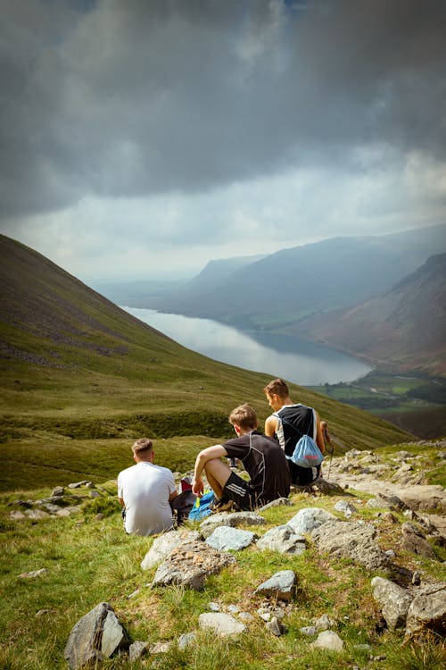 A Group of People Sitting on a Hill and Looking at the View