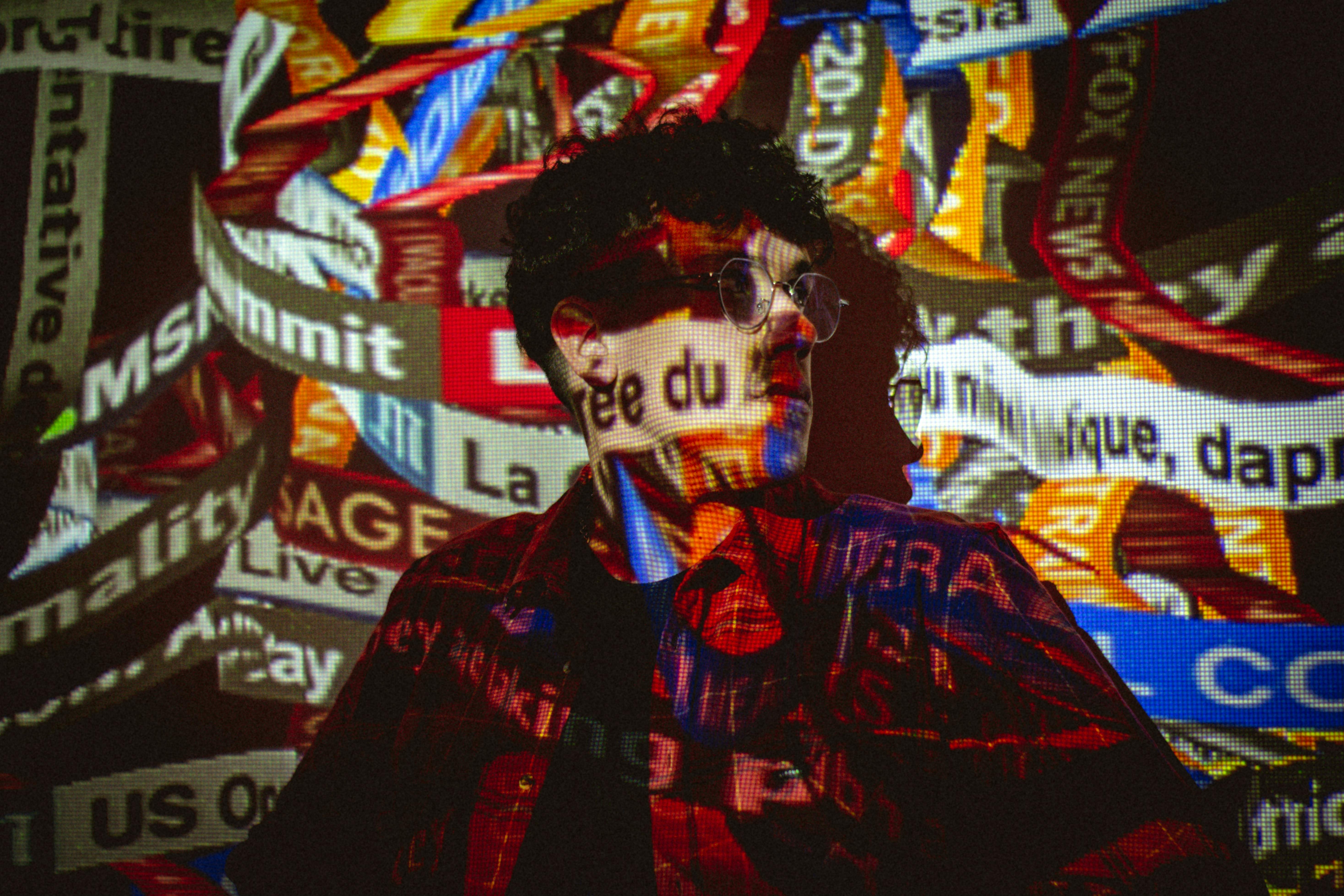 multi colored labels screening on standing man in eyeglasses