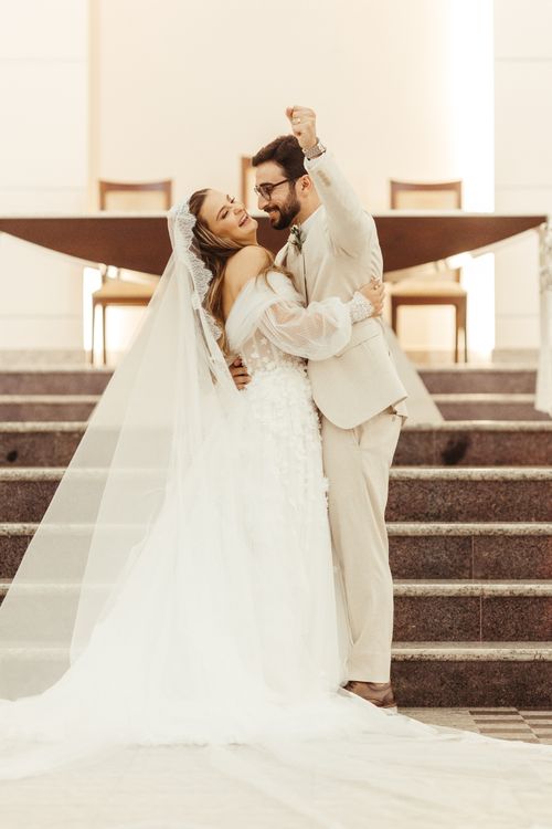 Free Happy couple celebrates wedding day with an embrace on grand staircase. Stock Photo