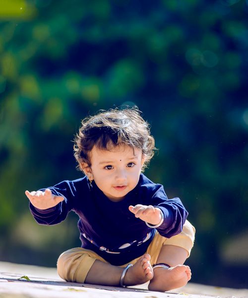 Free Cute child sitting outdoors in stylish clothing, perfect for fashion and lifestyle themes. Stock Photo