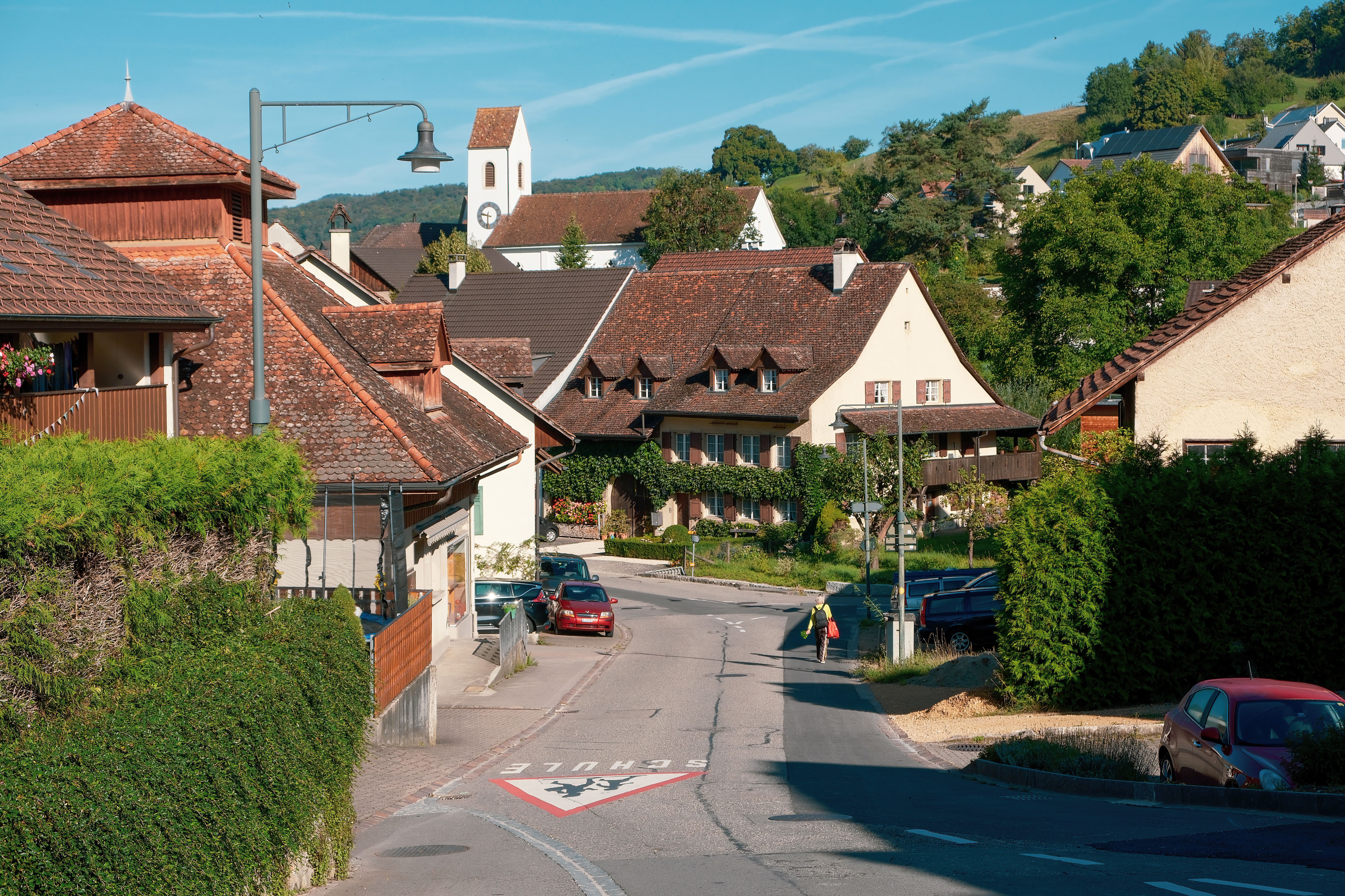 A picturesque European town street with traditional architecture bathed in sunlight.