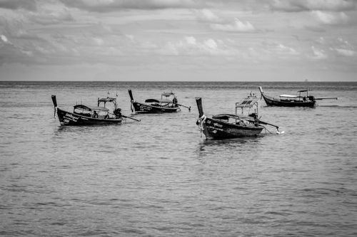 Free Black and white capture of traditional fishing boats on the Phuket sea, showcasing serene oceanic beauty. Stock Photo