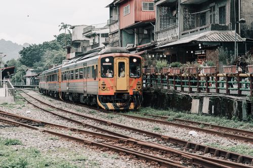 Free Historic train passing through a quaint urban neighborhood on a cloudy day. Stock Photo
