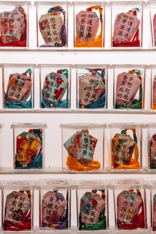 Free Close-up of a multi-colored display of Japanese omamori charms in plastic boxes. Stock Photo