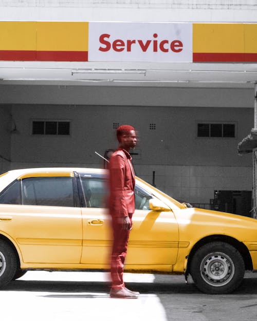 Red Man by the Yellow Car in Front of the Service