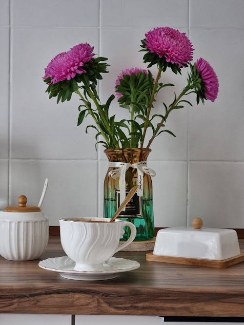A Cup of a Coffee and Flowers in a Vase on the Table