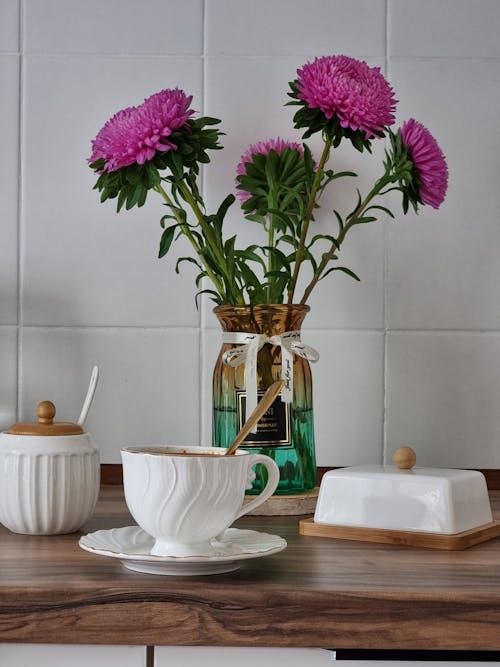 Free A Cup of a Coffee and Flowers in a Vase on the Table Stock Photo