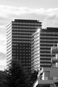 Black and white photo of modern skyscrapers against a cloudy sky in Neuhausen am Rheinfall.
