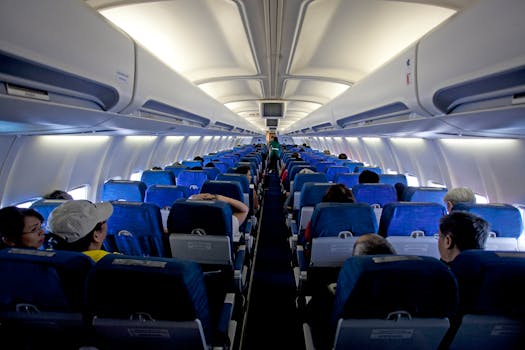 Symmetrical view of passengers inside a commercial airplane cabin during daytime travel.