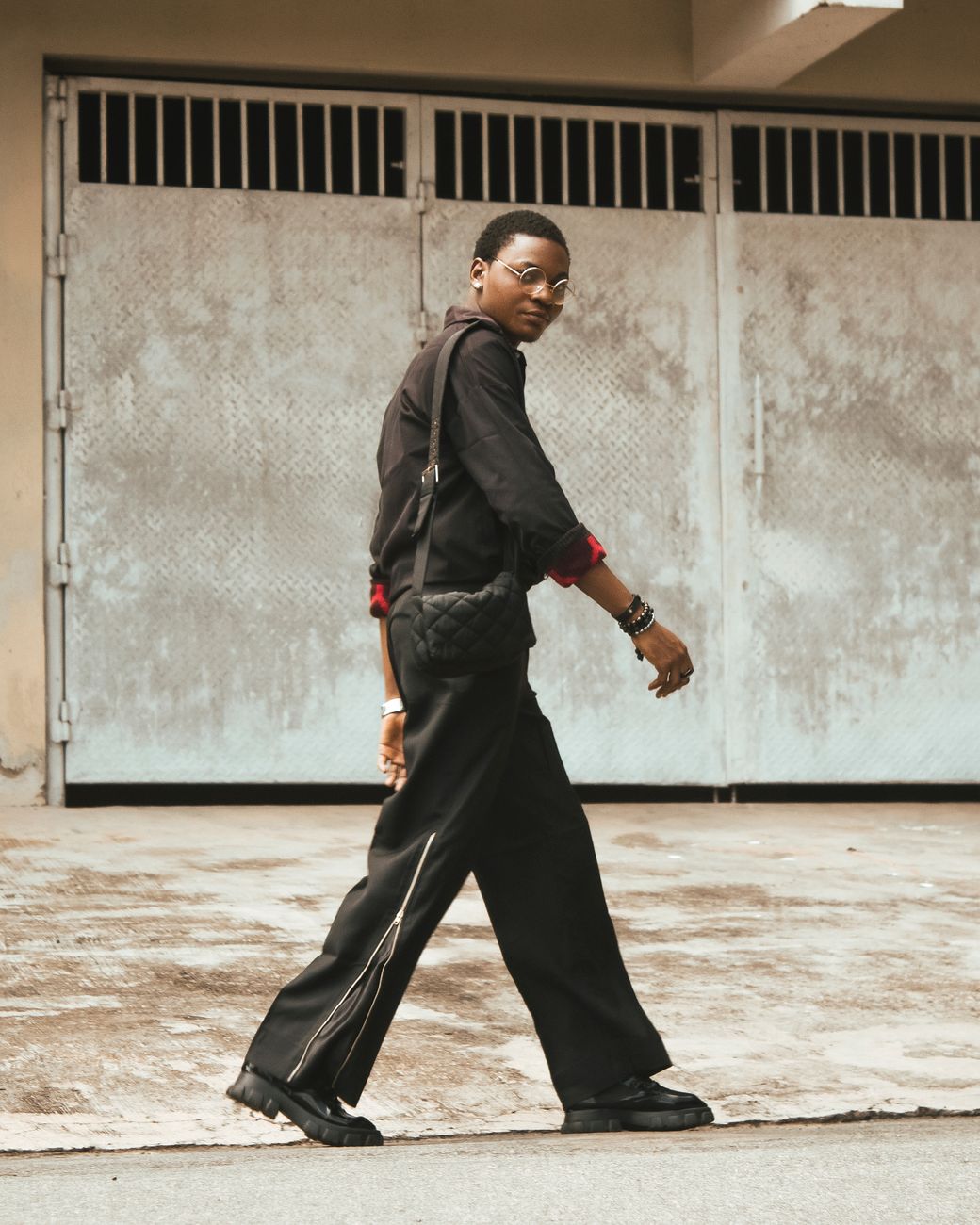 A fashionable man walking confidently on an urban street. Trendy and stylish in his outfit.