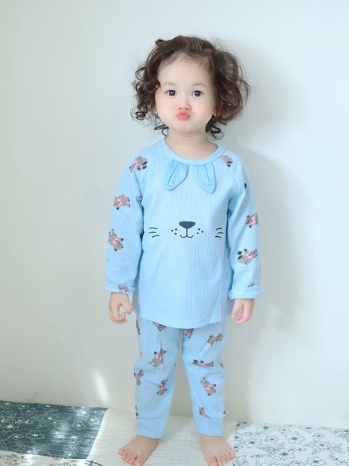 Free Cute toddler standing in blue pajamas with animal prints, making a funny face. Stock Photo