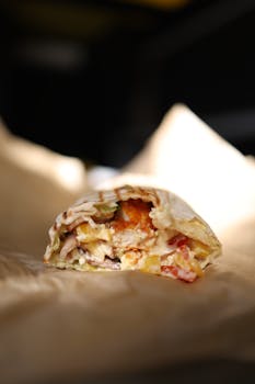 Delicious close-up of a fresh doner kebab with vegetables inside a wrap, perfect for food photography.