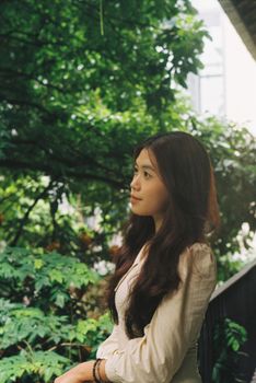 A serene portrait of a woman standing amidst vibrant greenery, showcasing natural beauty.