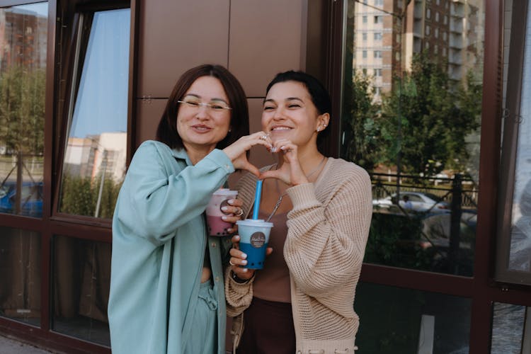 Smiling Women Showing Heart Gesture