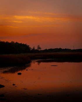 Tranquil evening view of a lake reflecting colorful sunset skies in Bournemouth, England.