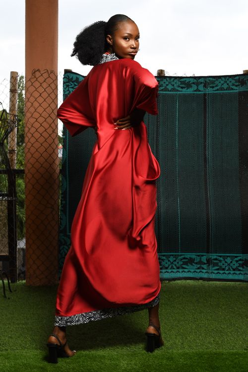 Free Stylish woman posing in a stunning red dress, outdoors. Stock Photo