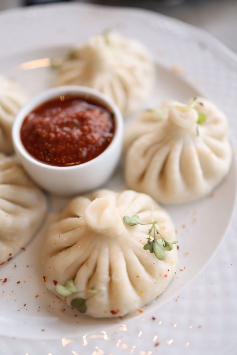 Hand-pleated khinkali dumplings served with a dipping sauce