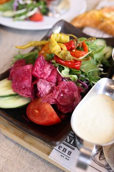 A healthy mixed salad with fresh vegetables and dressing, perfect for a nutritious meal.