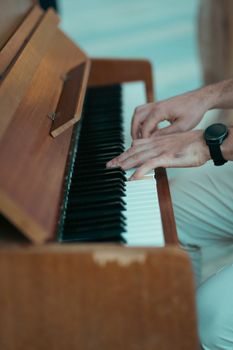 Hands playing a piano indoors. Warm, artistic vibe showcasing musical expression.