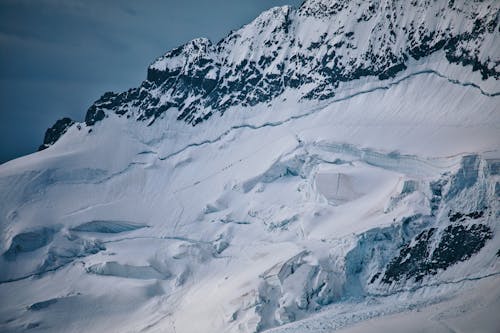 A snow covered mountain with a large snow covered peak