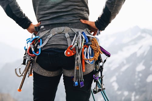 A person with a backpack and climbing gear on top of a mountain