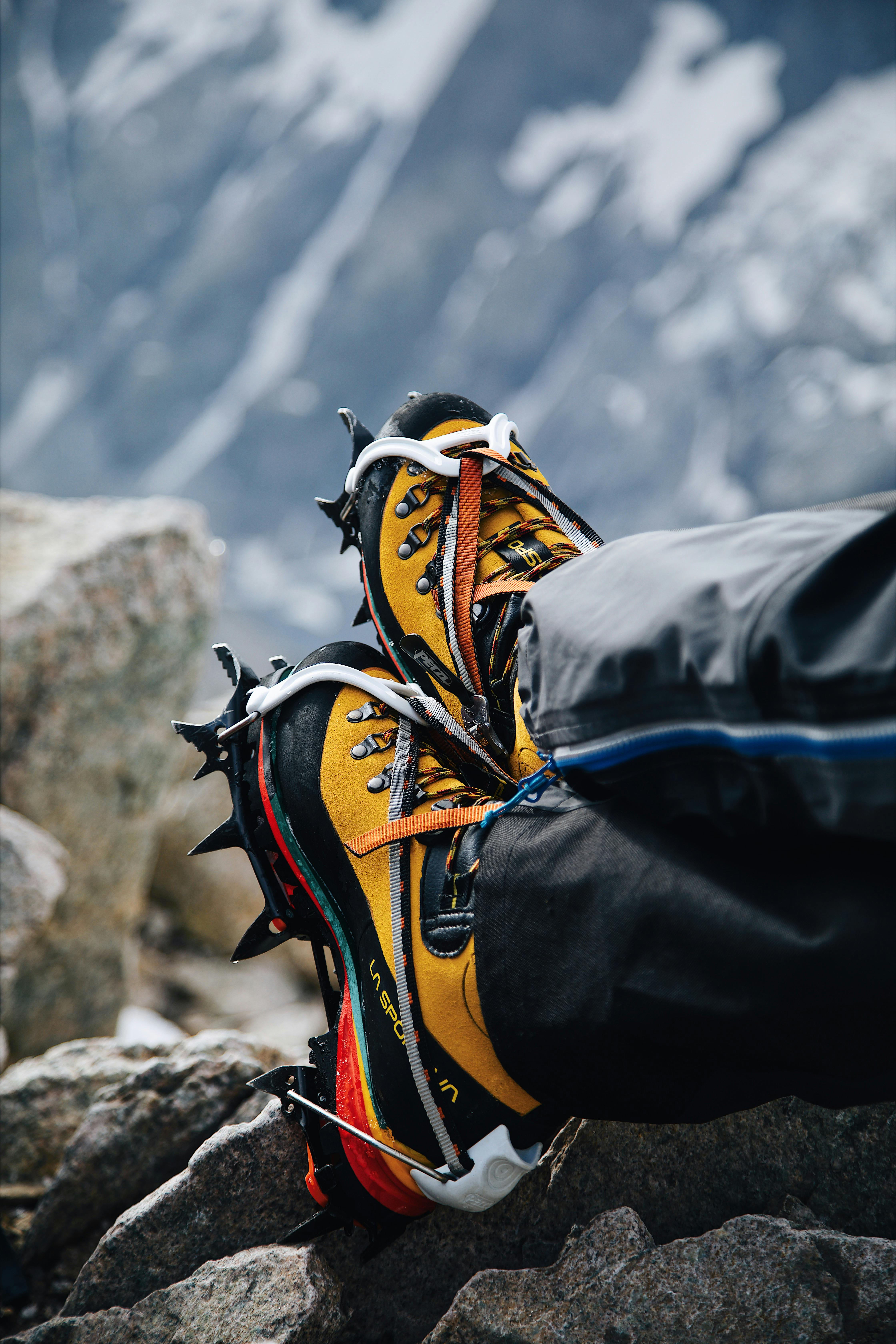 a person wearing yellow and black hiking shoes on top of a mountain